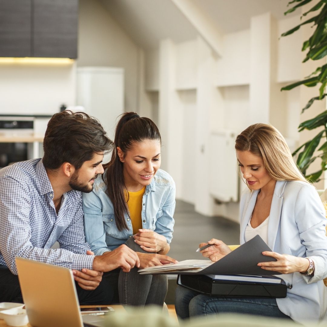 A realtor talking with two young clients