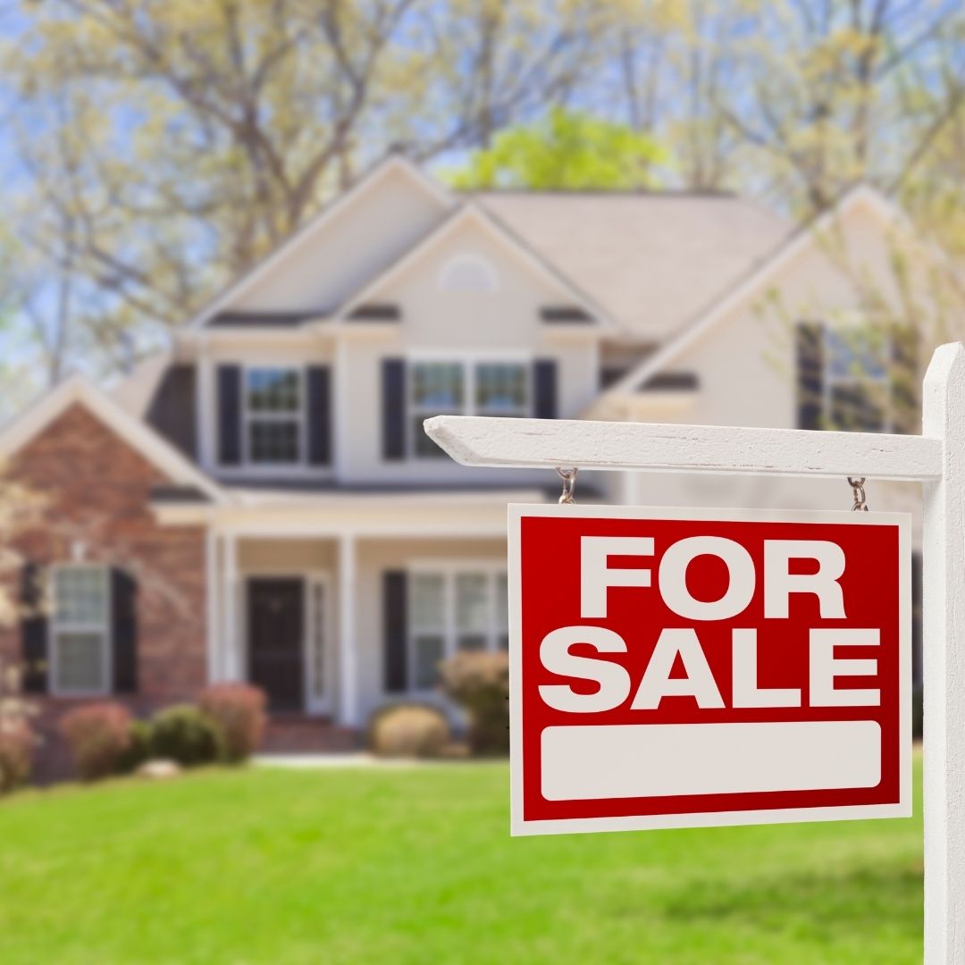 A house with a for sale sign in the yard